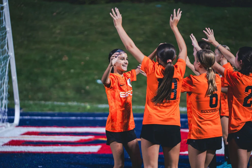 EAFC players celebrating together on the turf.