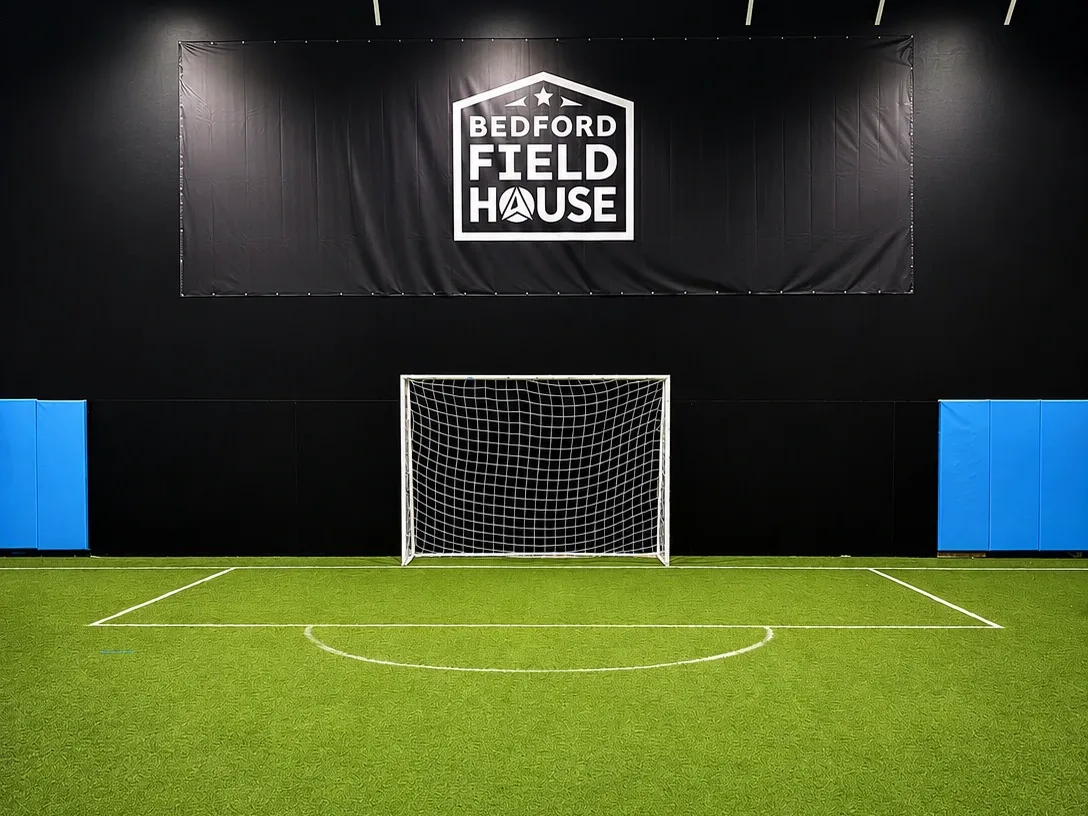 Bedford Field House indoor turf field with a goal below the logo banner.